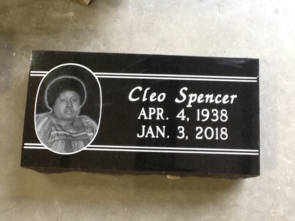 Gray granite flat headstone with porcelain photo inlay, photographed at the cemetery
